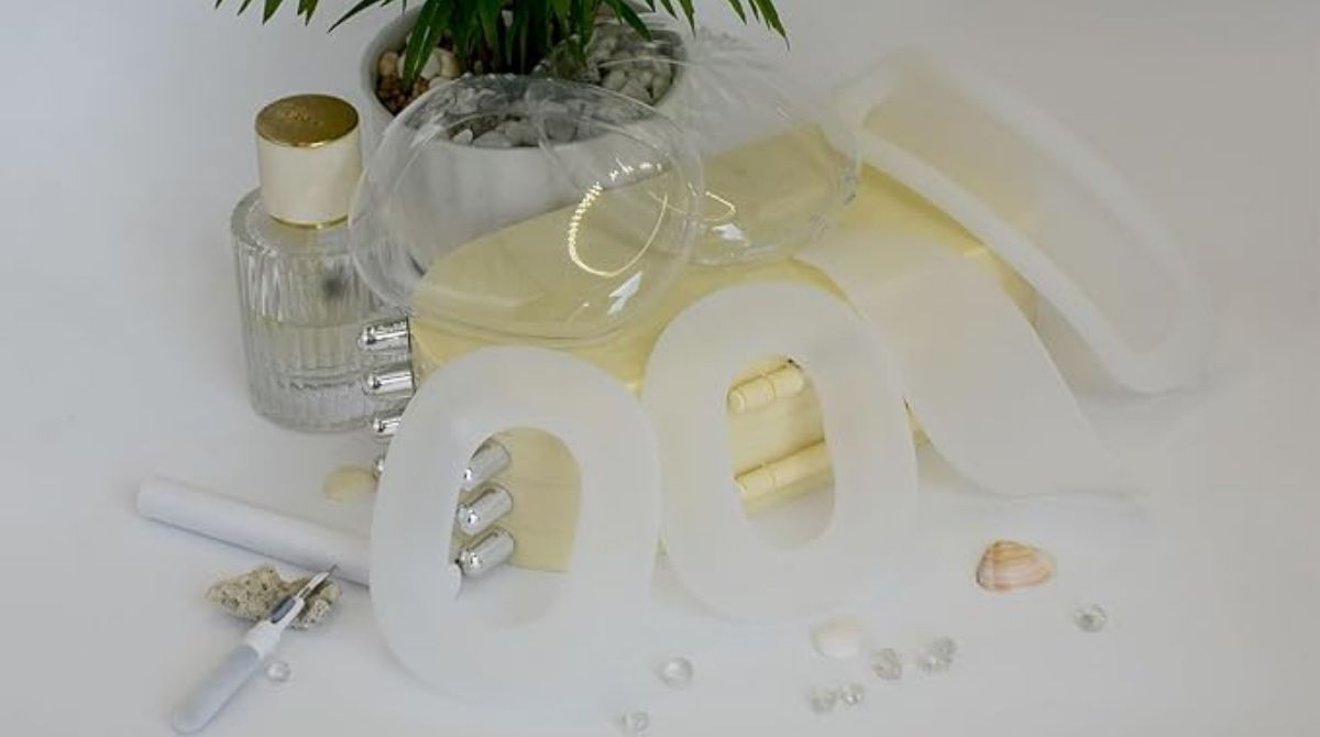 Protective silicone covers and cleaning kits for AirPods Max ear cups displayed with decorative items on a white surface.